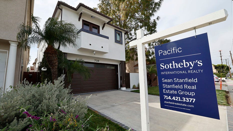 House with a for sale sign in yard